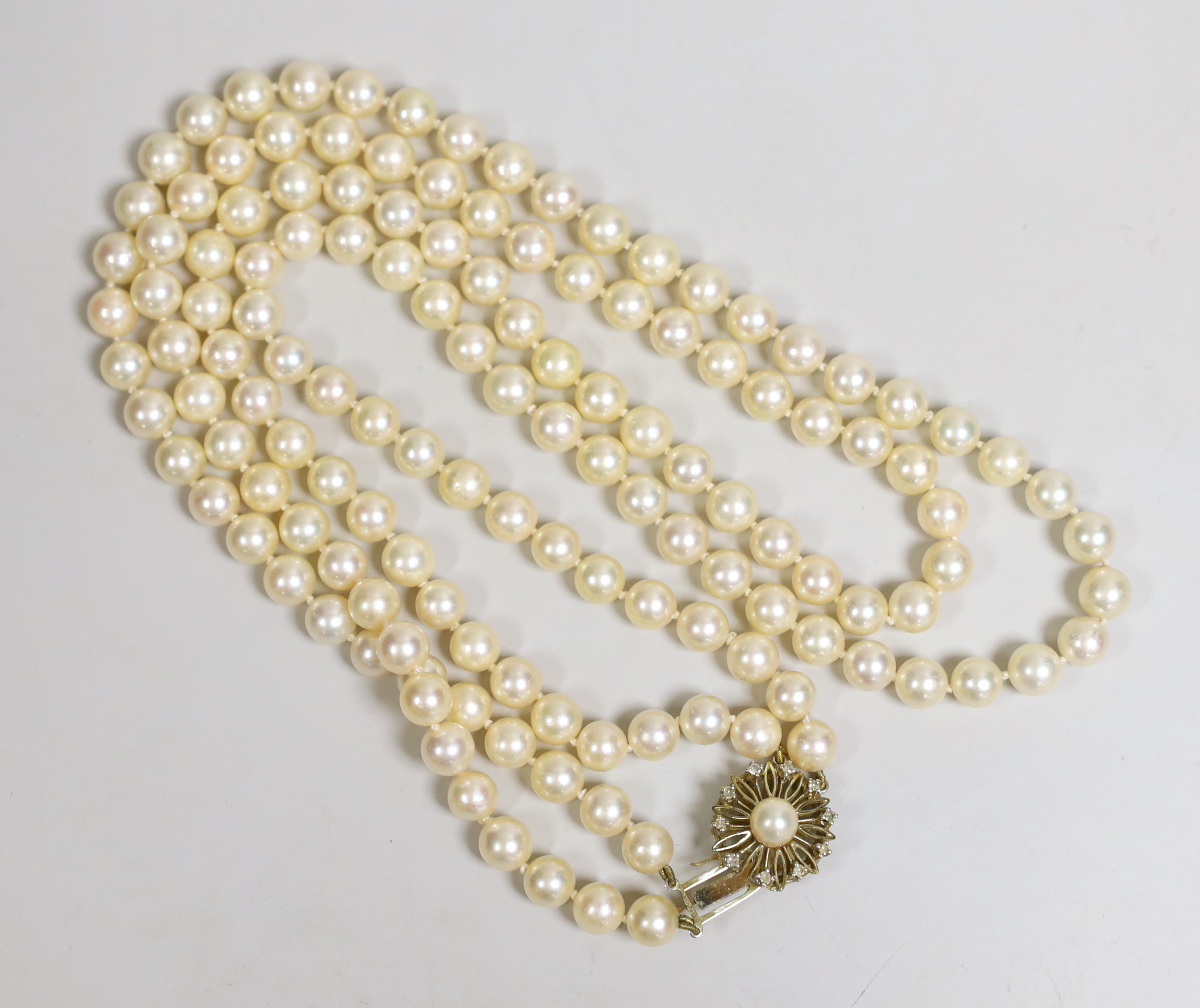 A twin strand cultured pearl necklace, with a cultured pearl and diamond chip set yellow metal clasp, 63cm.